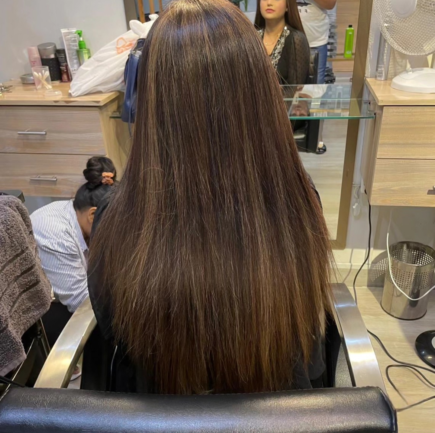 Back view of long chestnut brown hair blow-dried sleek and glass-smooth at TONES Salon Lahore